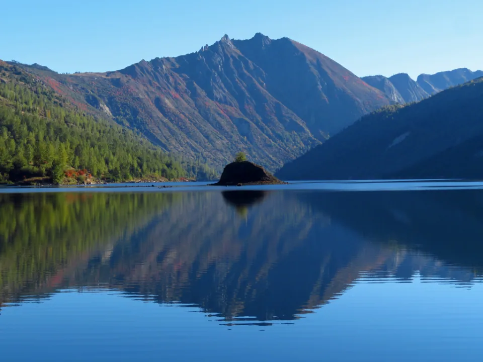 Still mountain lake reflecting the peaks above it