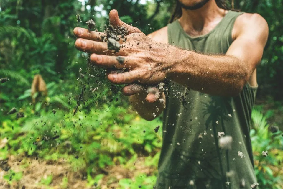 A volunteer holding a handful of planting soil